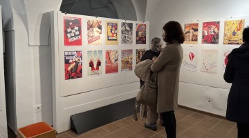 Varias personas observan los carteles de la exposición