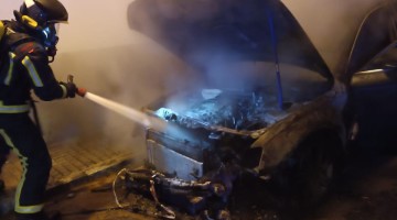 Un bombero sofocando el incendio del vehículo